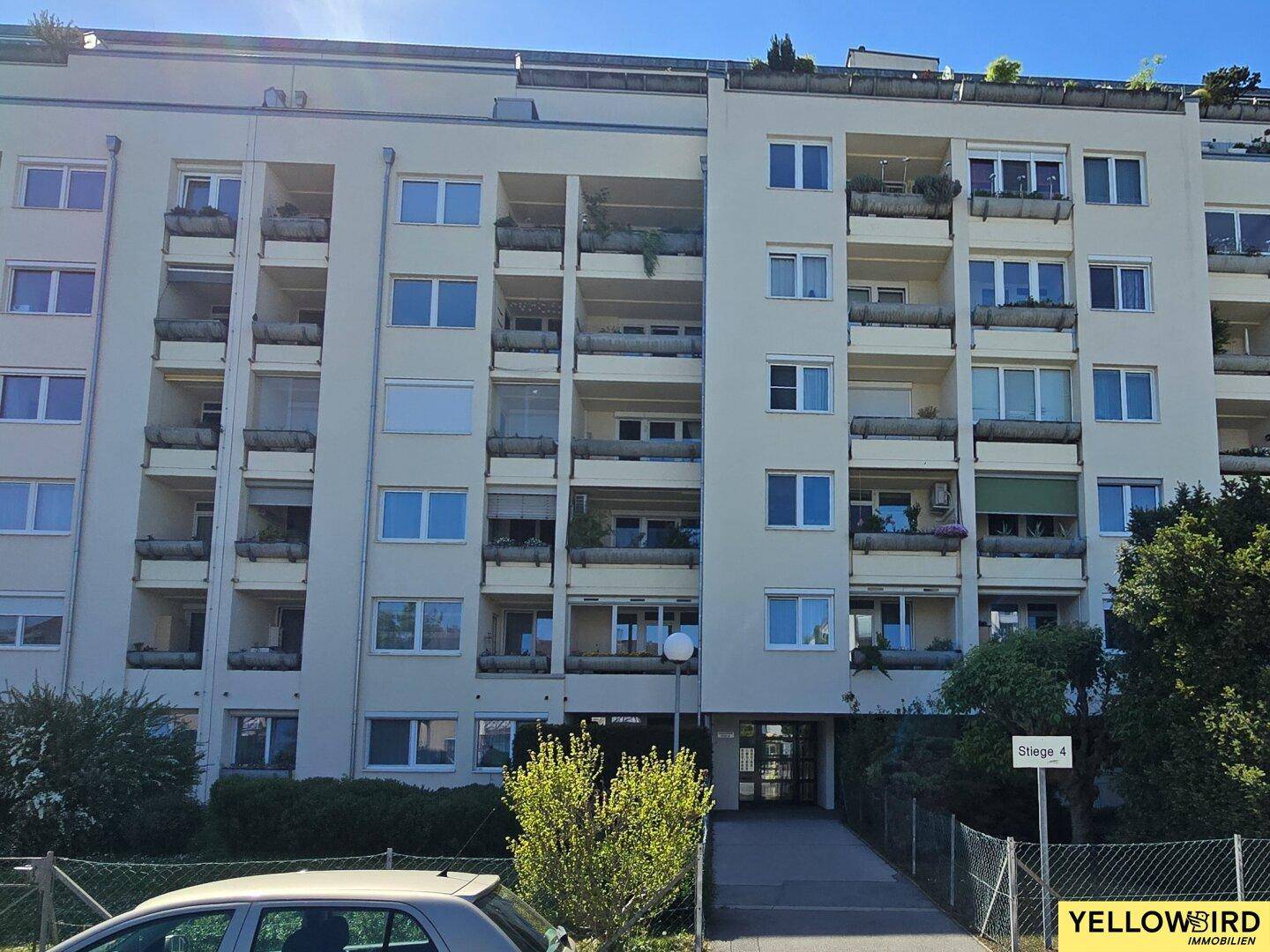 Mehrstöckiges Apartmentgebäude mit zahlreichen Balkonen und heller Fassade.