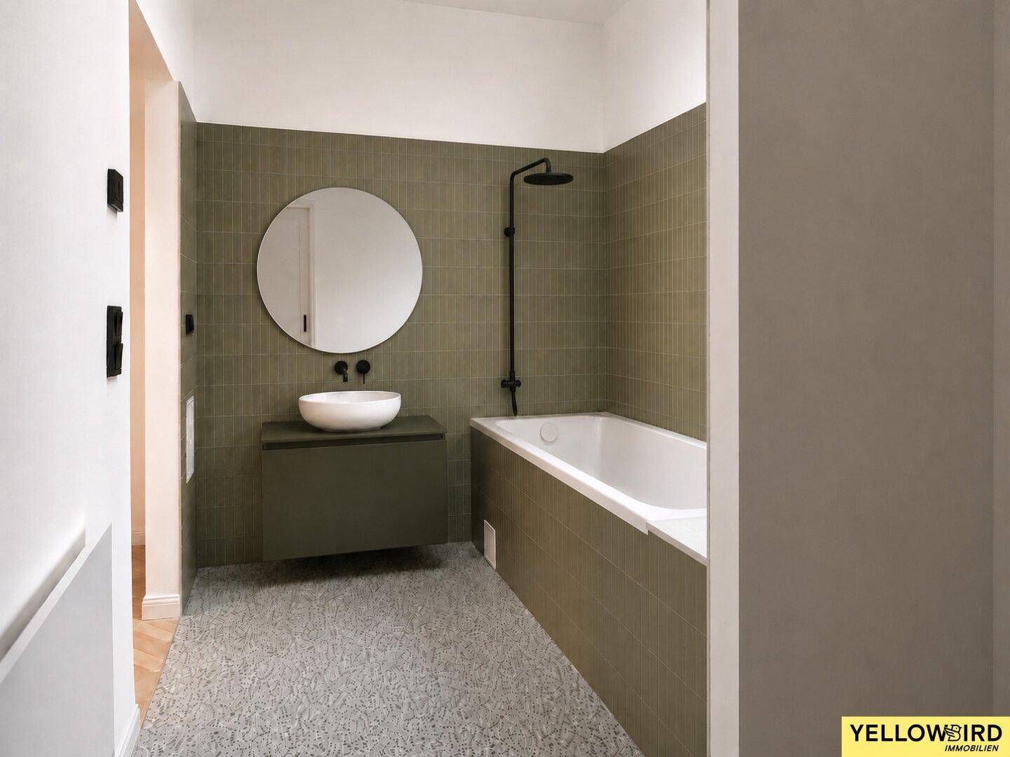 Modernes Badezimmer mit grünen Fliesen, Badewanne, rundem Spiegel und Einzelwaschbecken.