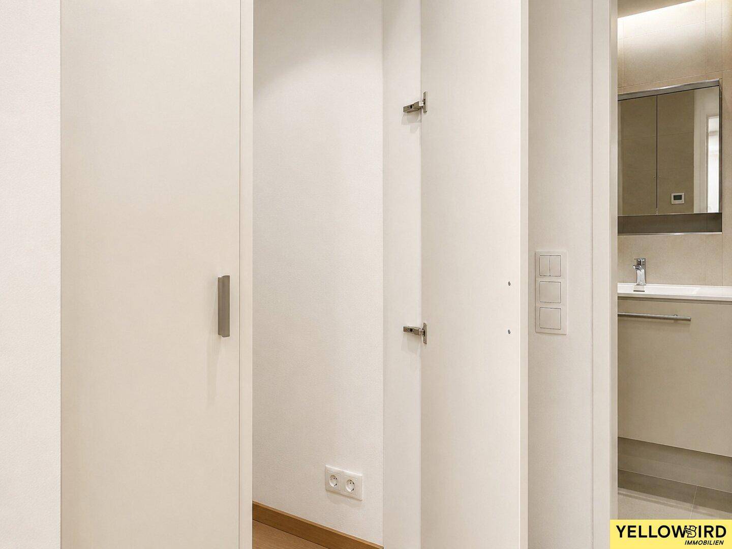 Heller Flurbereich mit Zugang zum Badezimmer, das moderne Armaturen zeigt.