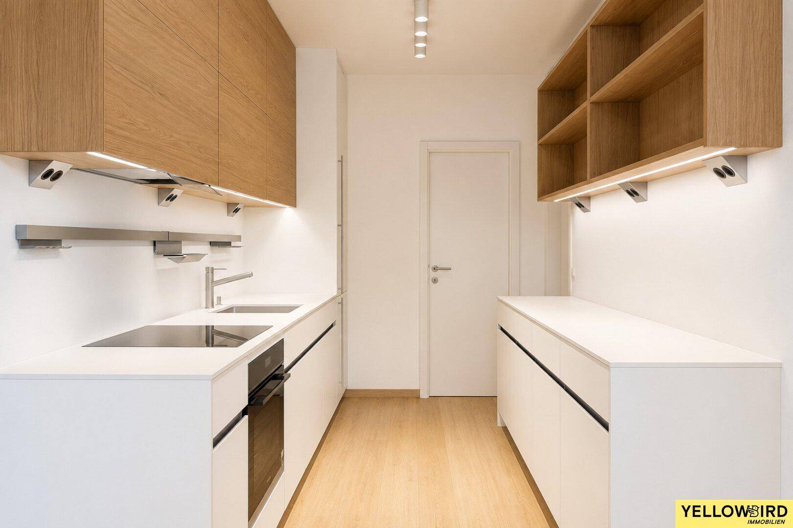 Moderne Küche mit weißen Unterschränken, Holz-Oberschränken und integrierten Geräten.