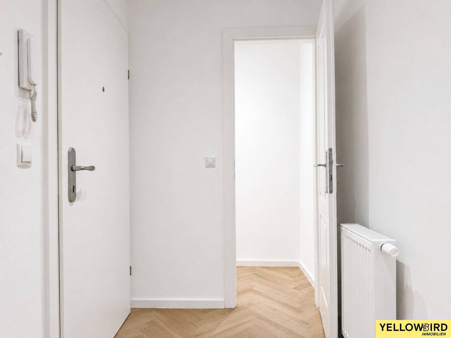 Heller Eingangsbereich mit Gegensprechanlage und Zugang zu den Wohnräumen.