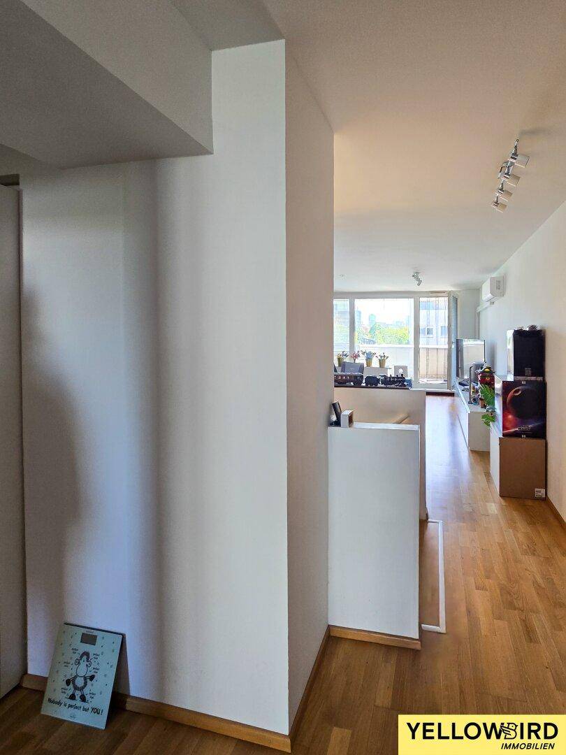 Heller Eingangsbereich mit Parkettboden und Blick in den offenen Wohnbereich der Wohnung.