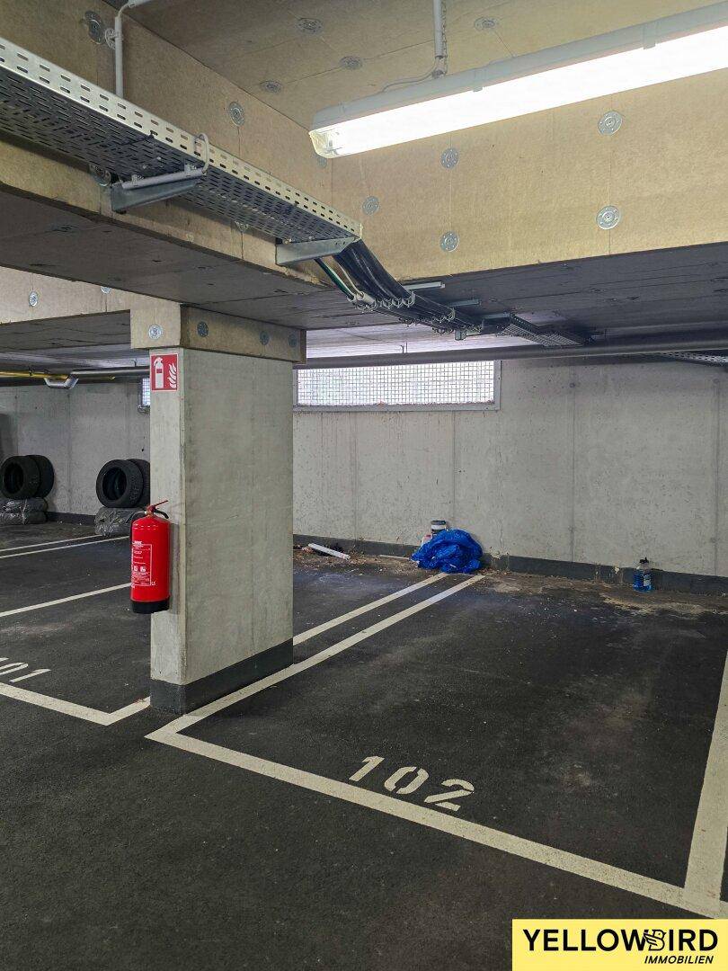 Tiefgarage mit markierten Stellplätzen und Betonkonstruktion, gut beleuchtet.