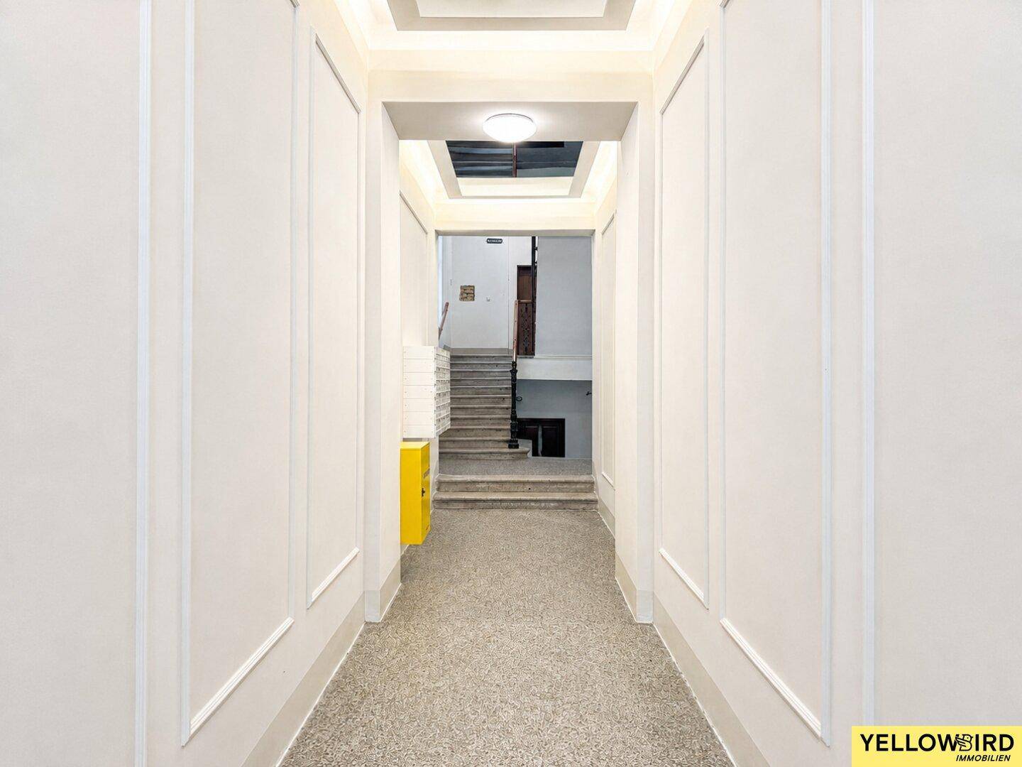 Heller Flur im Eingangsbereich des Gebäudes mit Zugang zum Treppenhaus.