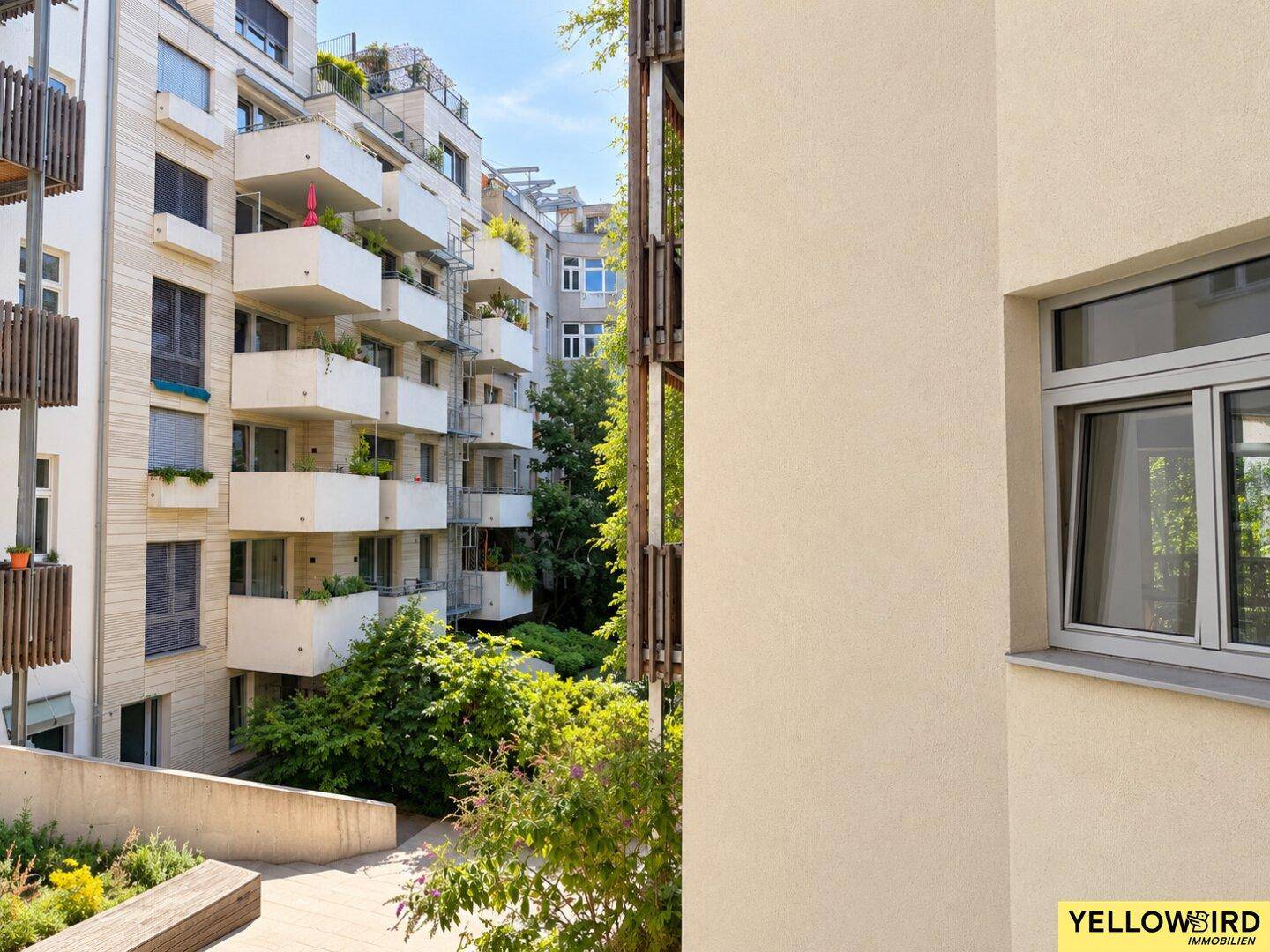 Ansicht eines modernen Apartmentkomplexes mit zahlreichen Balkonen und begrünten Außenbereichen.