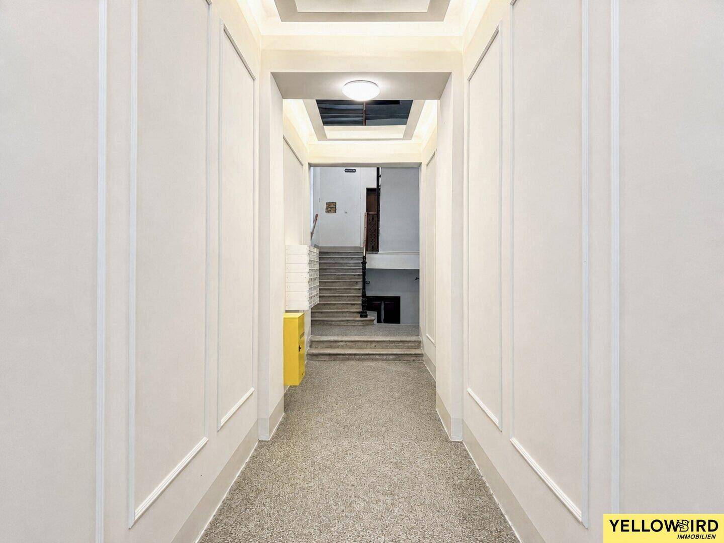 Heller Eingangsbereich mit modernem Design und Zugang zum Treppenhaus.