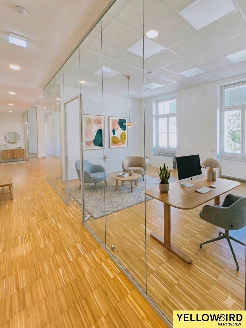 Modern eingerichtetes Büro mit Glaswänden, Holzboden und Blick auf die Stadt, ideal für eine produktive Arbeitsumgebung.