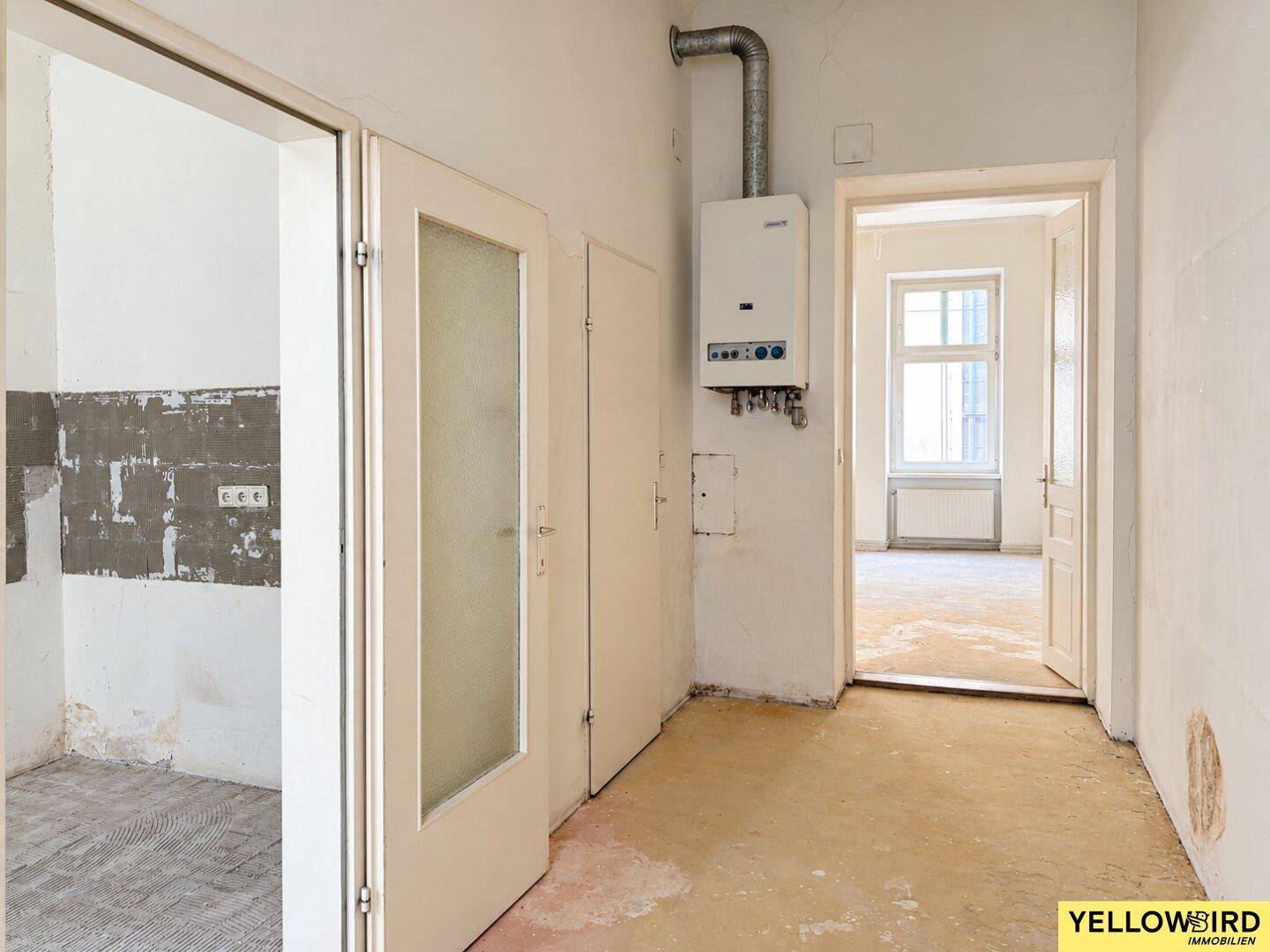 Flur mit Gastherme an der Wand und offenen Türen zu weiteren Räumen.