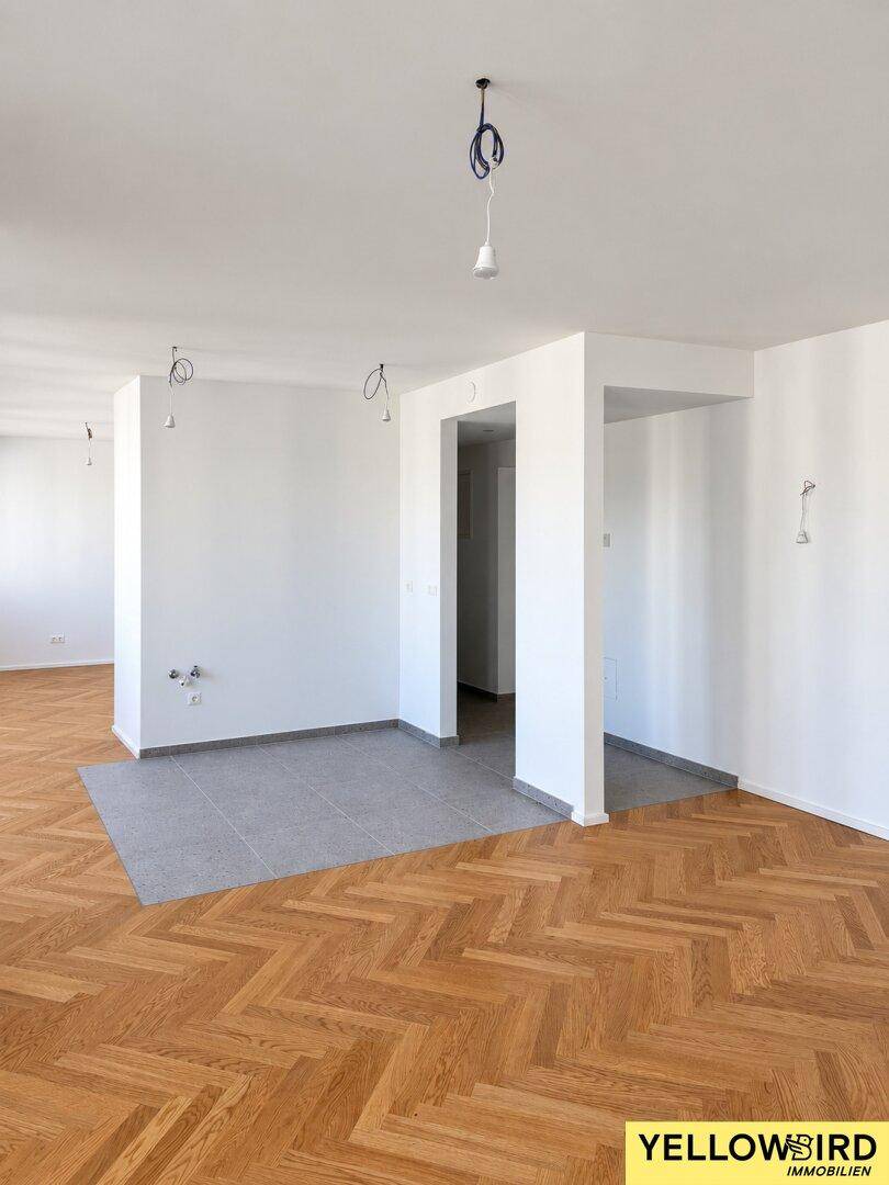 Geräumiger offener Bereich mit Fischgrätparkett und modernen Fliesen, ideal für Wohn- und Essbereiche.