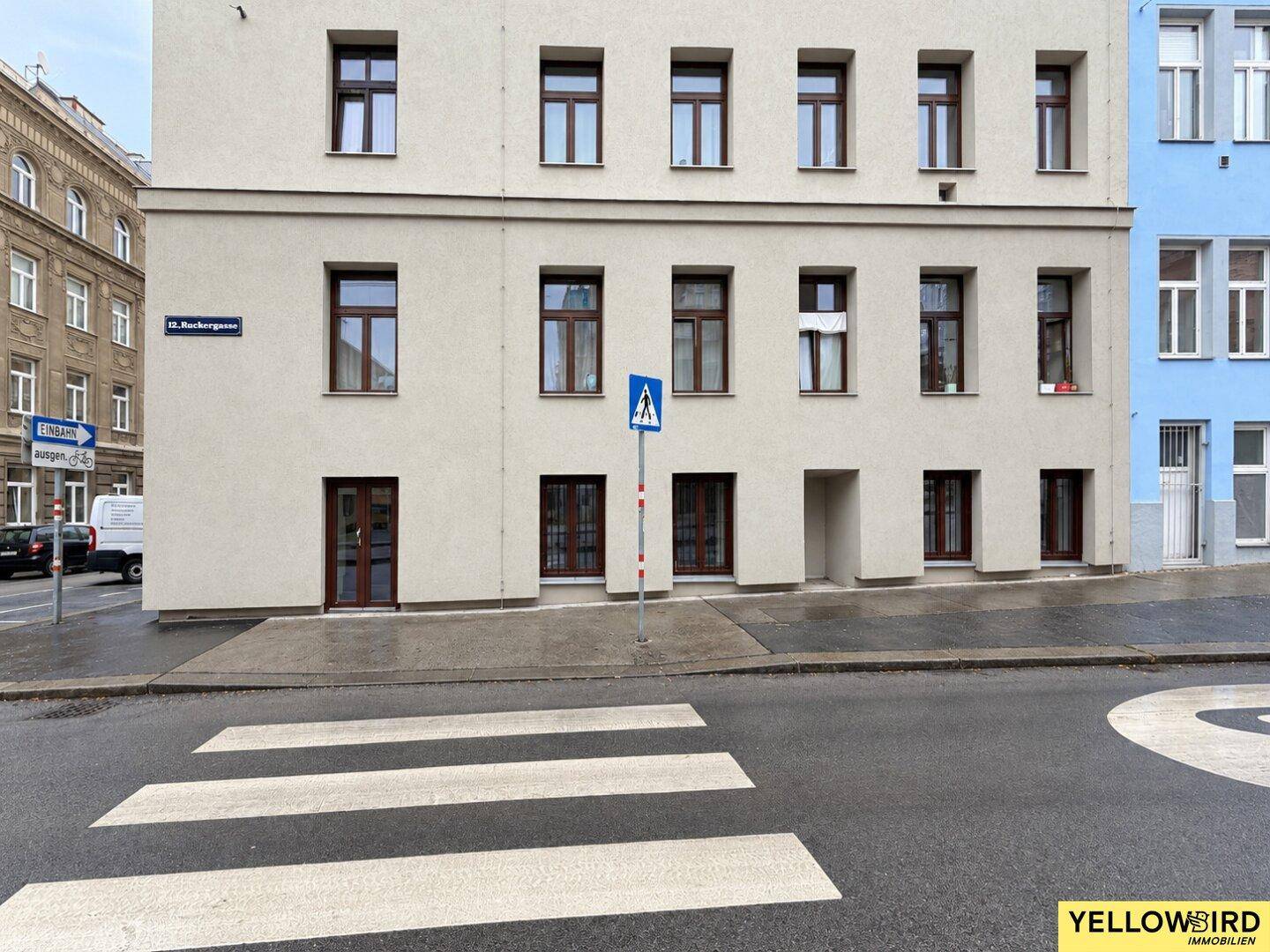 Außenansicht eines Gebäudes mit mehreren Fenstern und Türen, gesehen von der Straße.