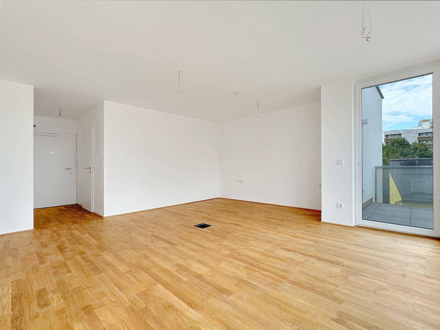 Geräumiges, helles Zimmer mit Holzboden, Zugang zum Balkon und moderner Ausstattung.