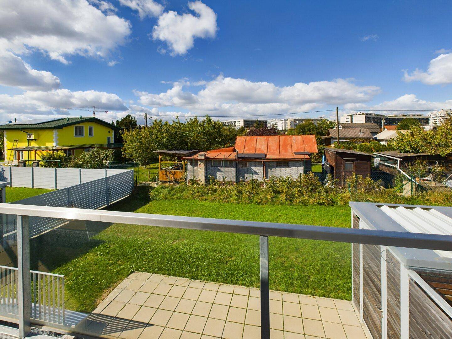 Balkon mit Fliesenboden und Glasgeländer bietet einen weiten Blick auf die Umgebung.