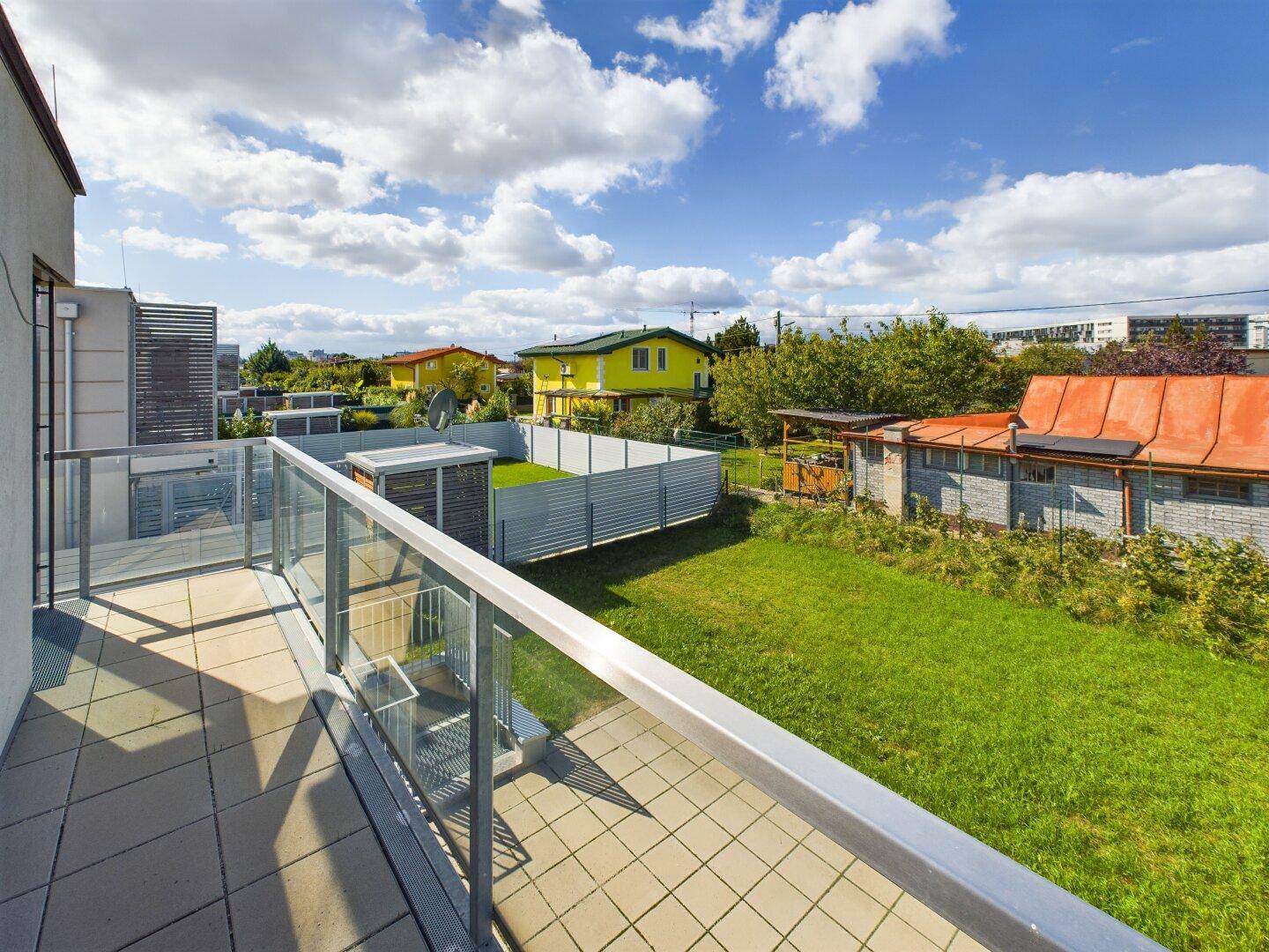 Geräumiger Balkon mit Fliesen und Glasbrüstung, ideal für Entspannung im Freien.
