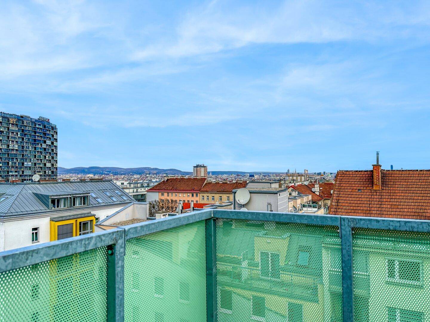Weitläufiger Blick über die Stadt und umliegende Dächer von der oberen Etage des Gebäudes.