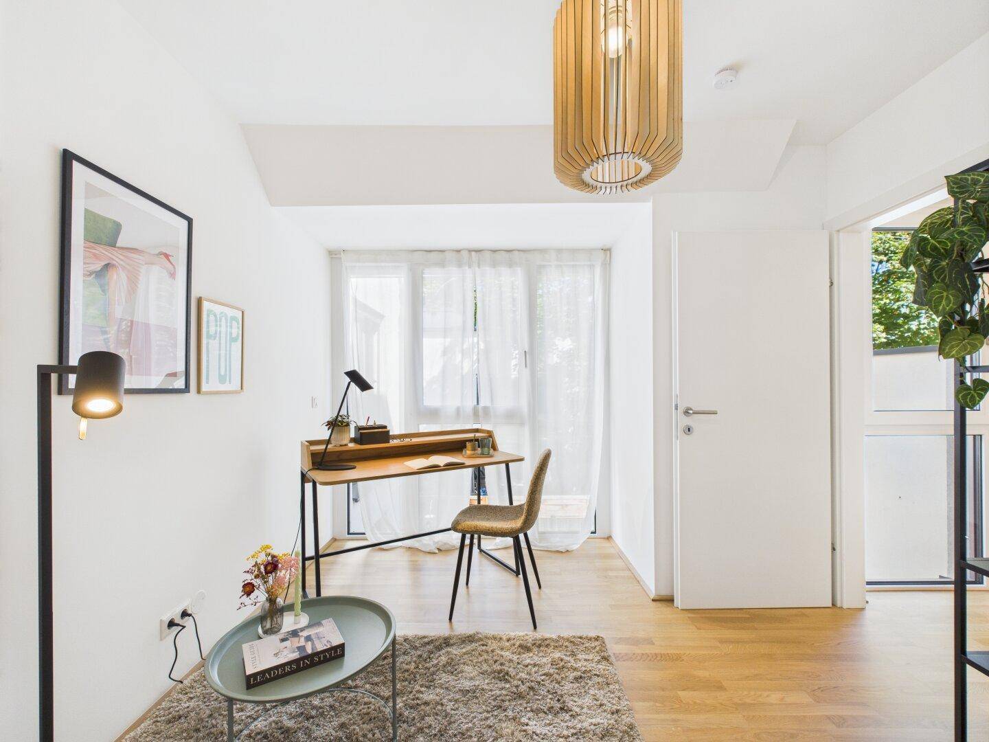 Gemütliches Arbeitszimmer mit Holzboden, Schreibtisch und Zugang zu einem Außenbereich.