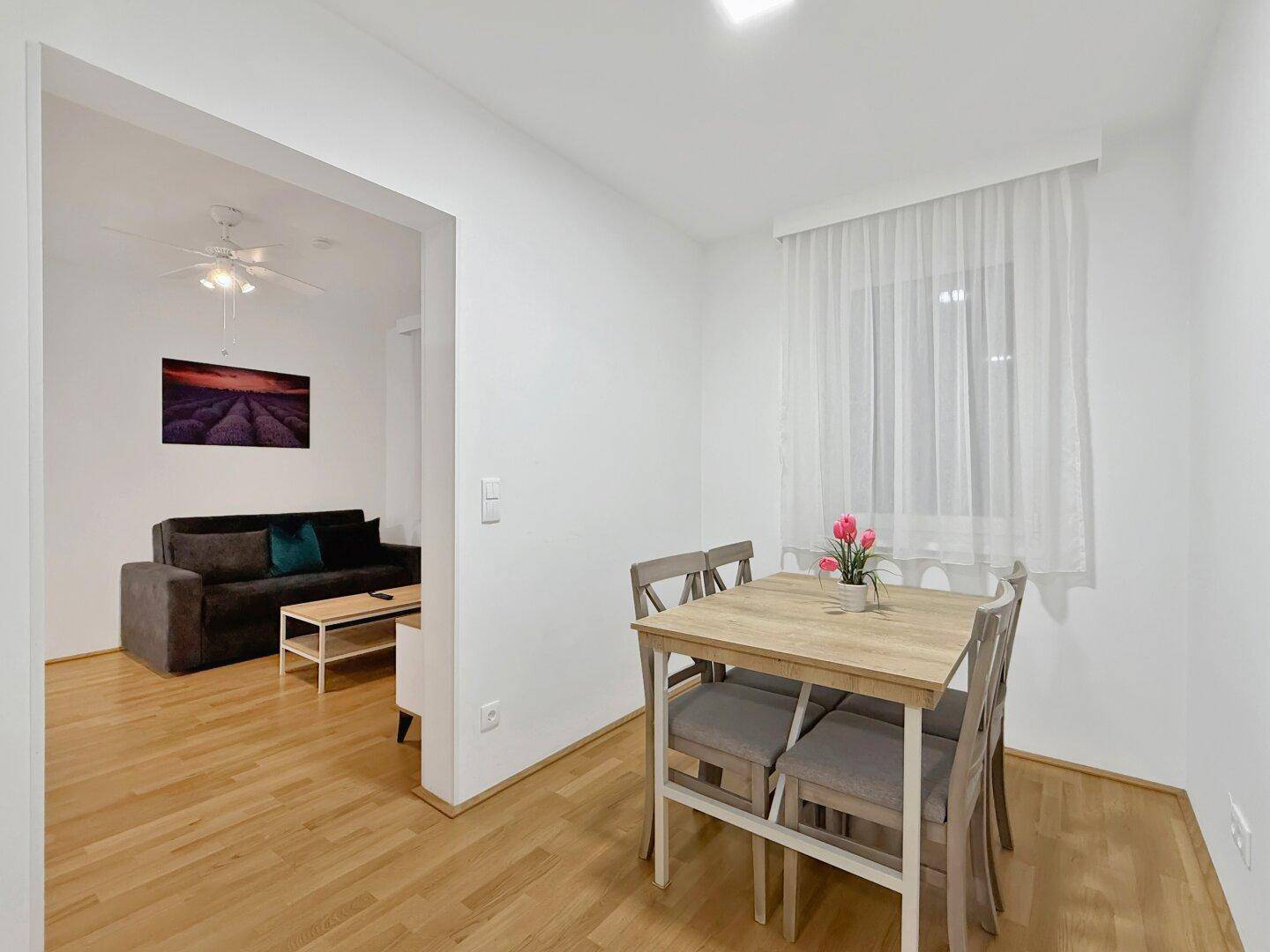 Gemütlicher Essbereich mit Holztisch und Stühlen, offen zum Wohnzimmer.