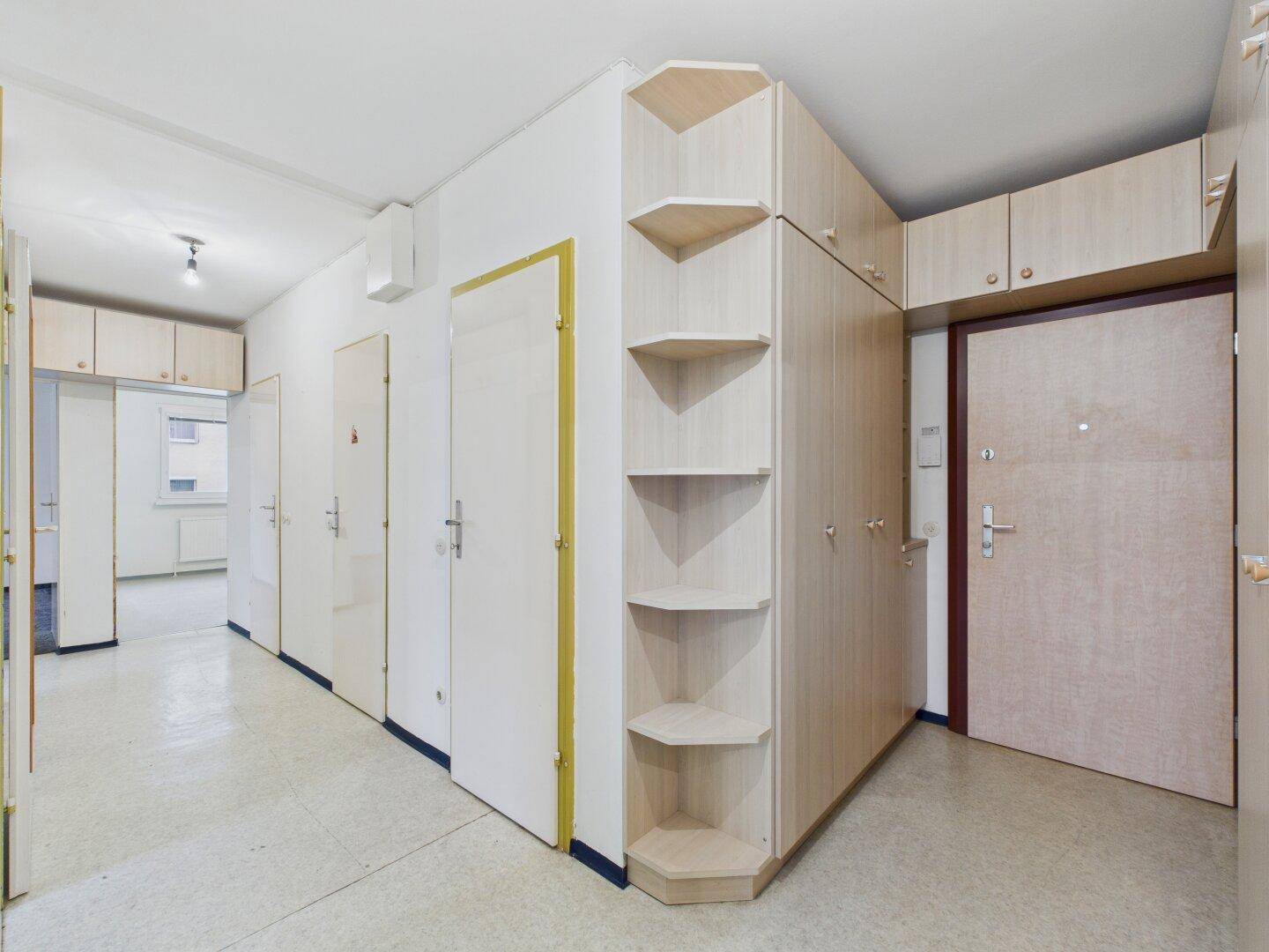 Heller Flur mit Einbauschränken und mehreren Türen, funktional gestaltet.