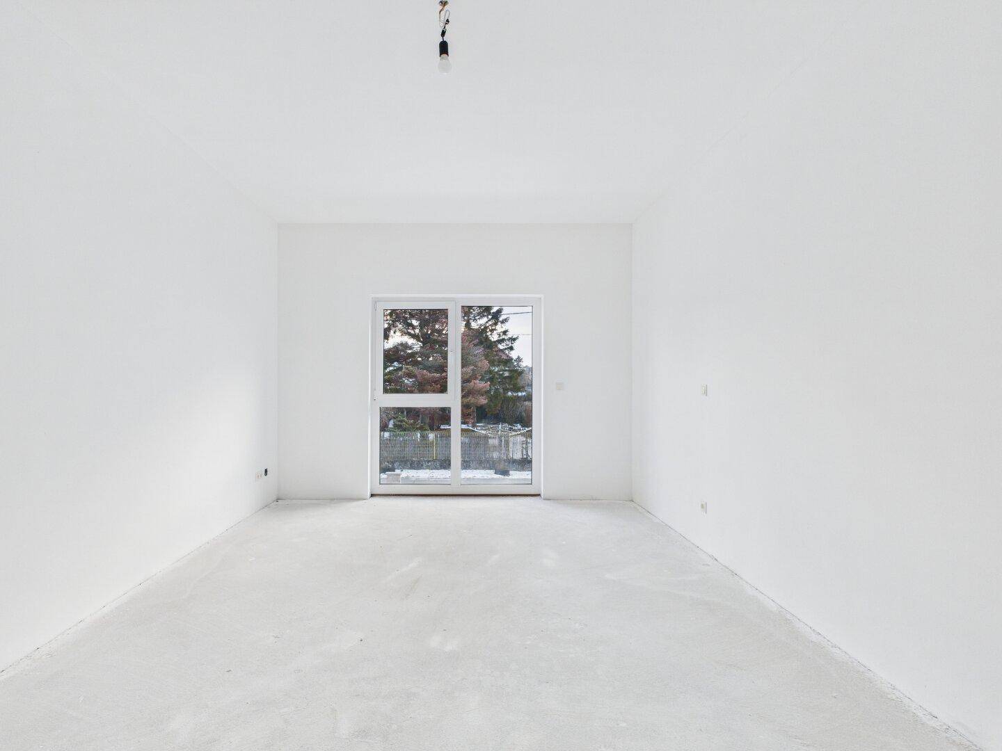 Leerer Raum im Rohbau mit großem Fenster und Blick ins Freie, ideal für ein Schlafzimmer.