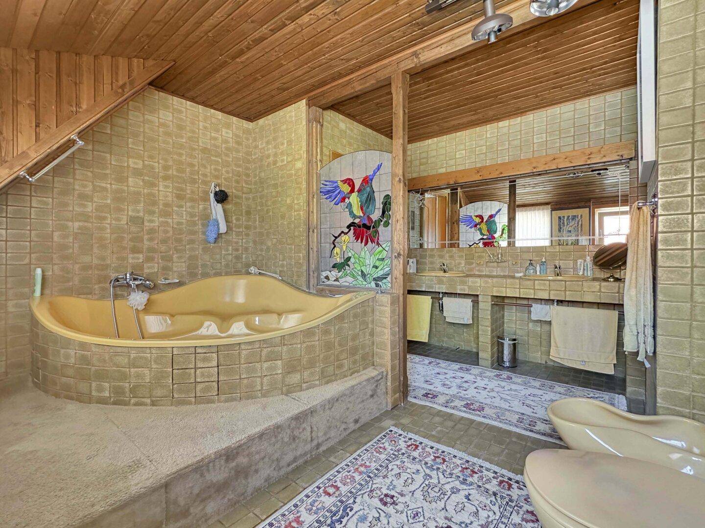 Großes Badezimmer mit gelber Badewanne, Doppelwaschbecken und Holztäfelung an der Decke.