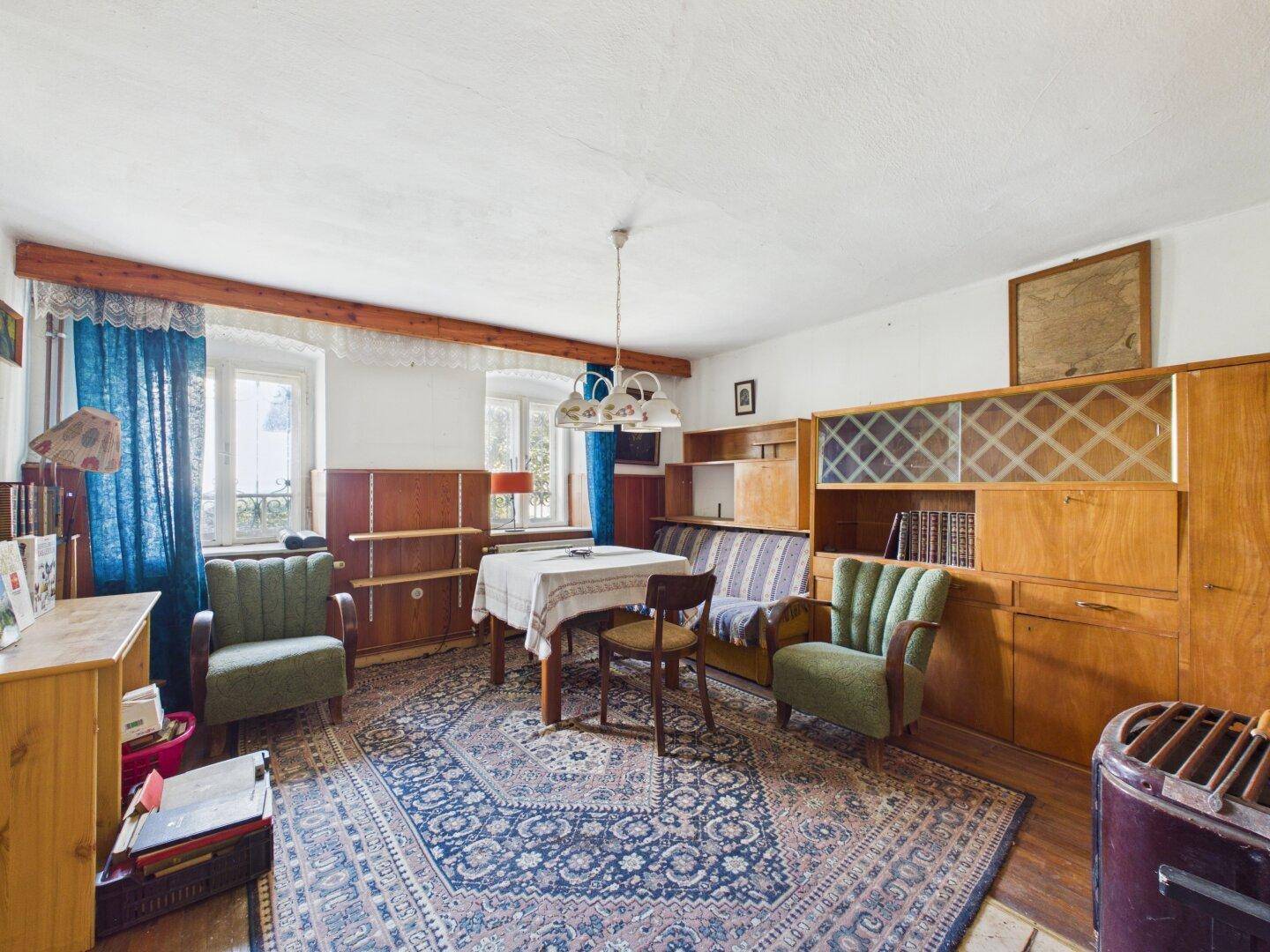 Wohnzimmer mit traditionellen Möbeln, Teppich und einem Holzofen.