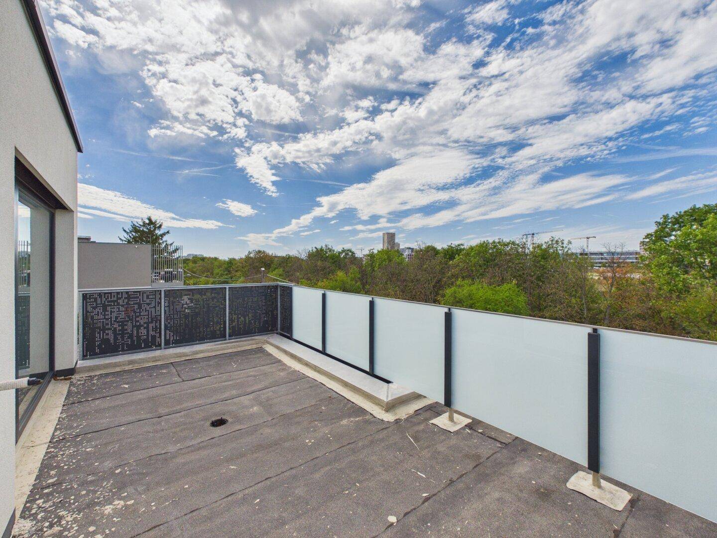 Große Dachterrasse mit moderner Verglasung und weitem Blick.