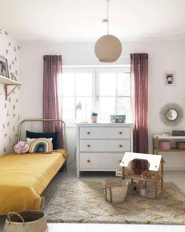 Kinderzimmer mit Einzelbett, Kommode und Spielzeug.