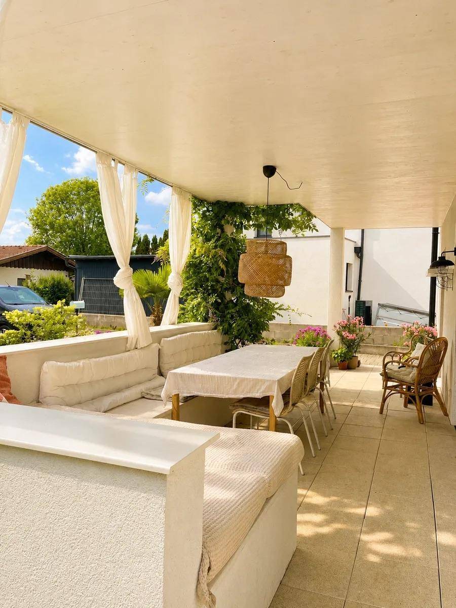 Geräumige überdachte Terrasse mit Essbereich und Lounge-Möbeln im Freien.
