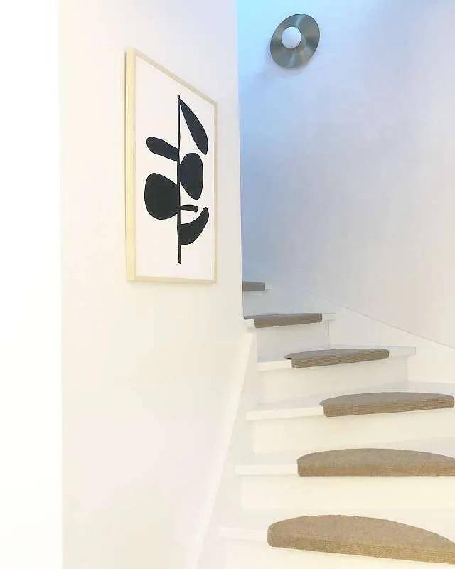 Heller Treppenaufgang mit minimalistischer Kunst und schwebenden Stufen.