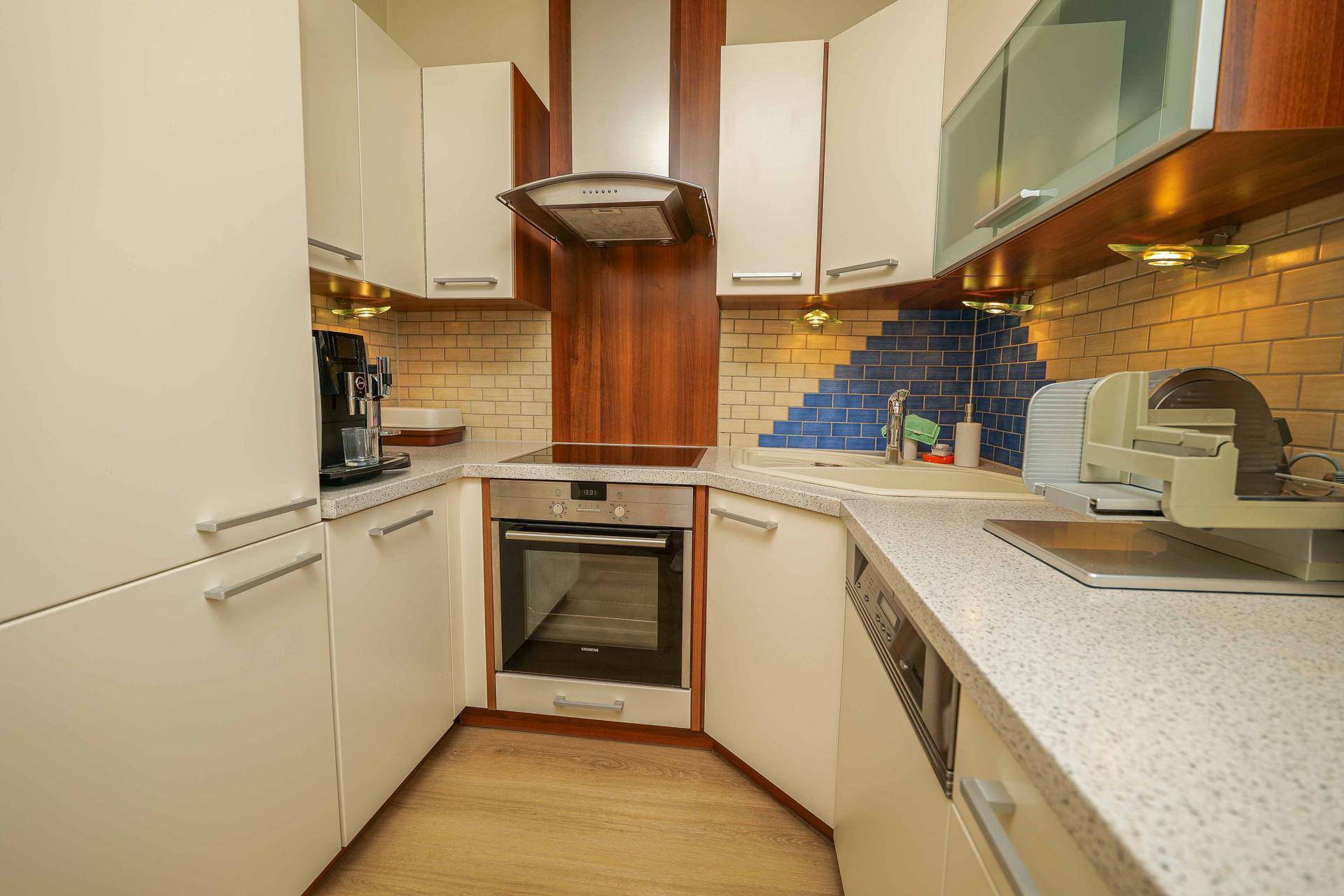 Funktionale Küche mit Eckspüle, Dunstabzugshaube und modernen Einbaugeräten.