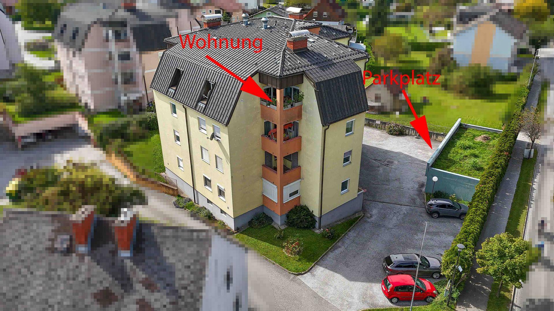 Luftaufnahme des Gebäudes mit markierter Wohnung und Parkplatz im Grünen.