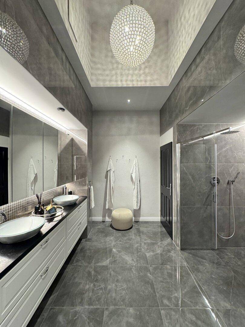 Modernes Badezimmer mit Doppelwaschbecken, großem Spiegel und begehbarer Dusche.