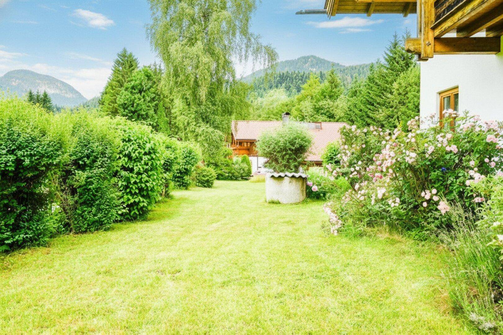Gepflegter Gartenweg mit blühenden Rosenbüschen und üppiger Heckenbepflanzung.