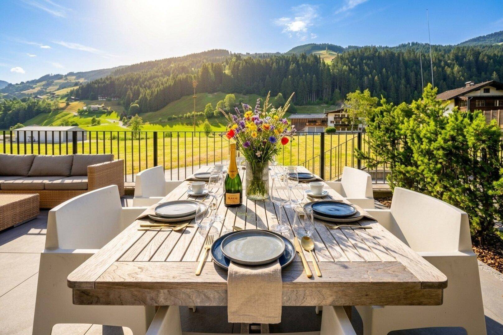 Malerischer Essplatz auf der Terrasse mit weitem Blick über die grüne Berglandschaft.