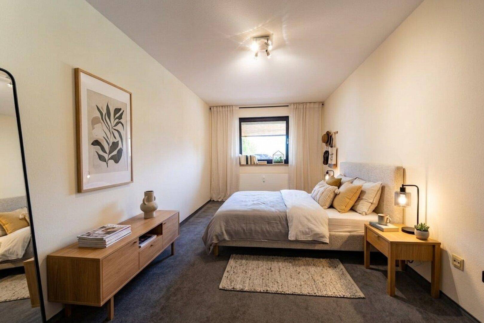 Modern eingerichtetes Schlafzimmer mit Doppelbett, Nachttischen und großem Spiegel.