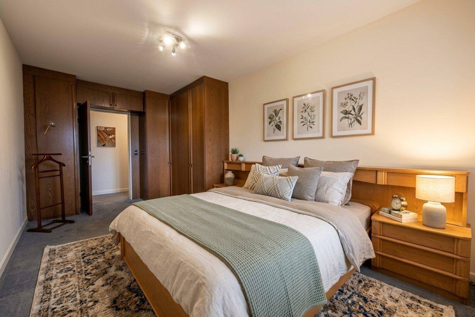 Geräumiges Schlafzimmer mit Einbauschränken, Doppelbett und klassischer Einrichtung.