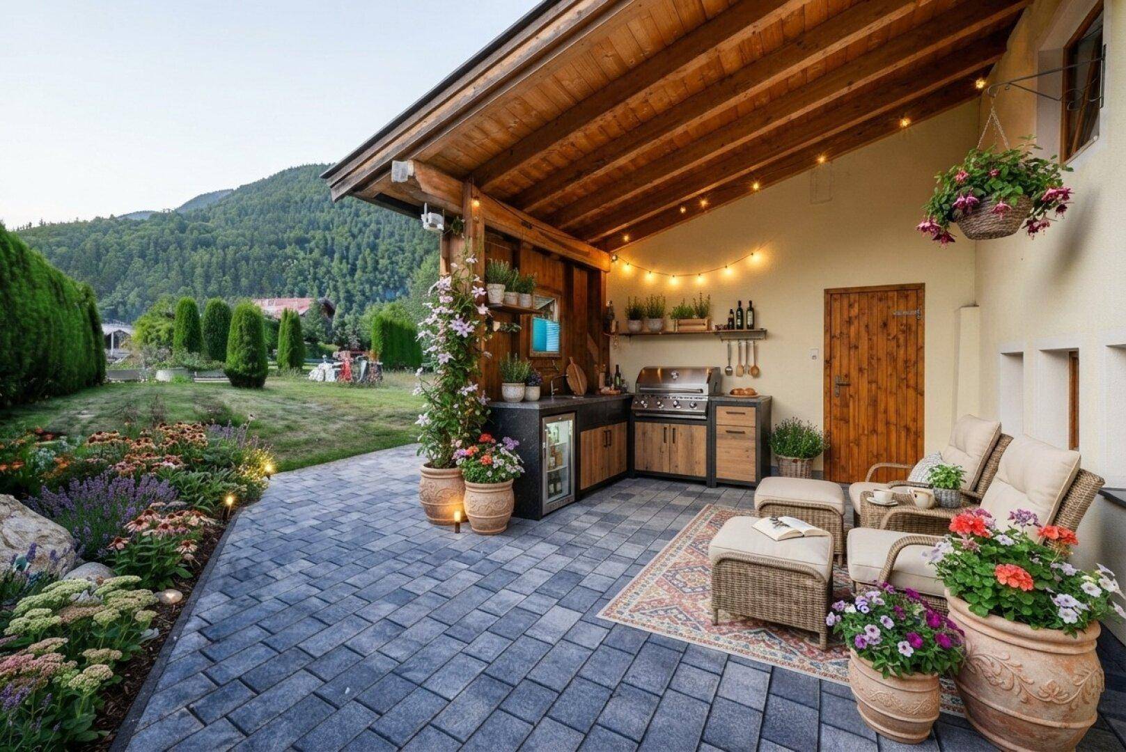 Überdachte Terrasse mit stilvoller Außenküche, gemütlicher Sitzecke und Blick ins Grüne.
