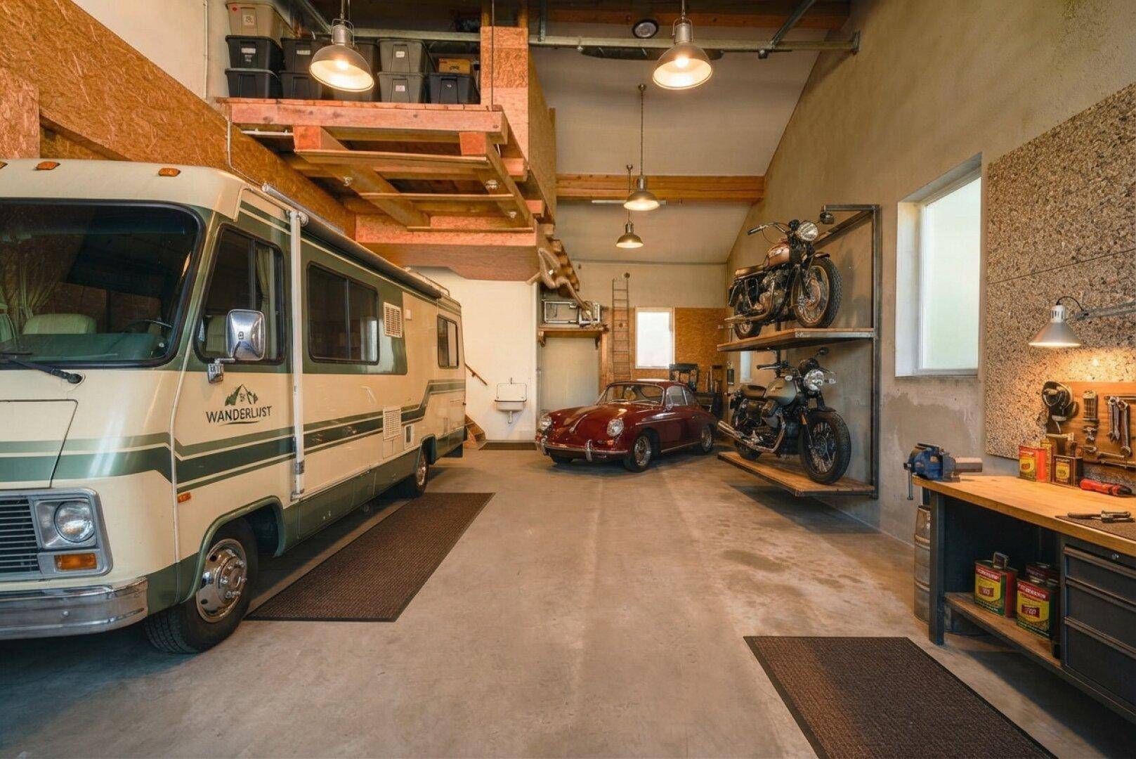 Geräumige Garage mit Wohnmobil, Oldtimer, Motorrädern und Werkstattbereich.