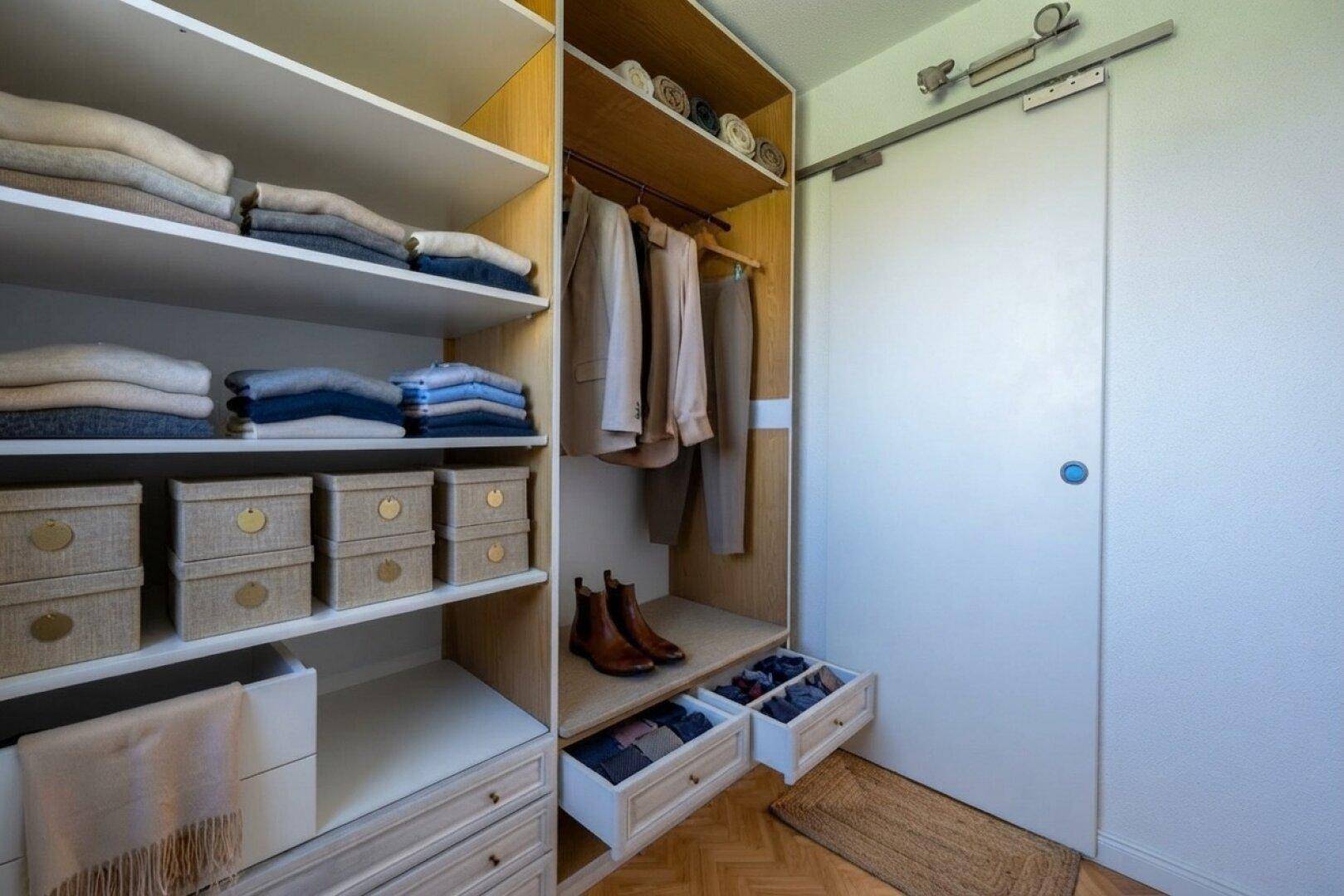 Gut organisierter begehbarer Kleiderschrank mit Regalen und Schubladen für Kleidung.