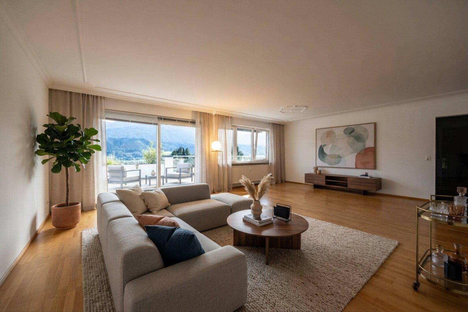 Geräumiges Wohnzimmer mit großem Sofa, Holzboden und Zugang zur Terrasse mit Bergblick.