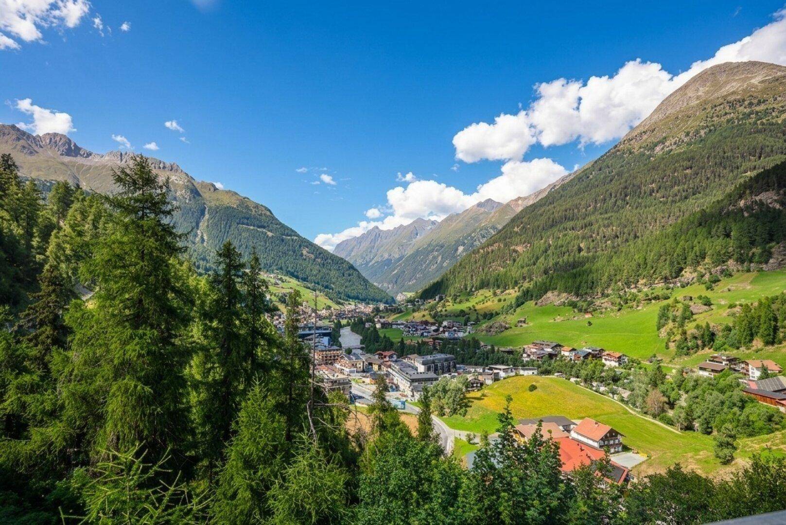 Panoramablick auf ein malerisches Tal mit Bergen und grüner Landschaft.