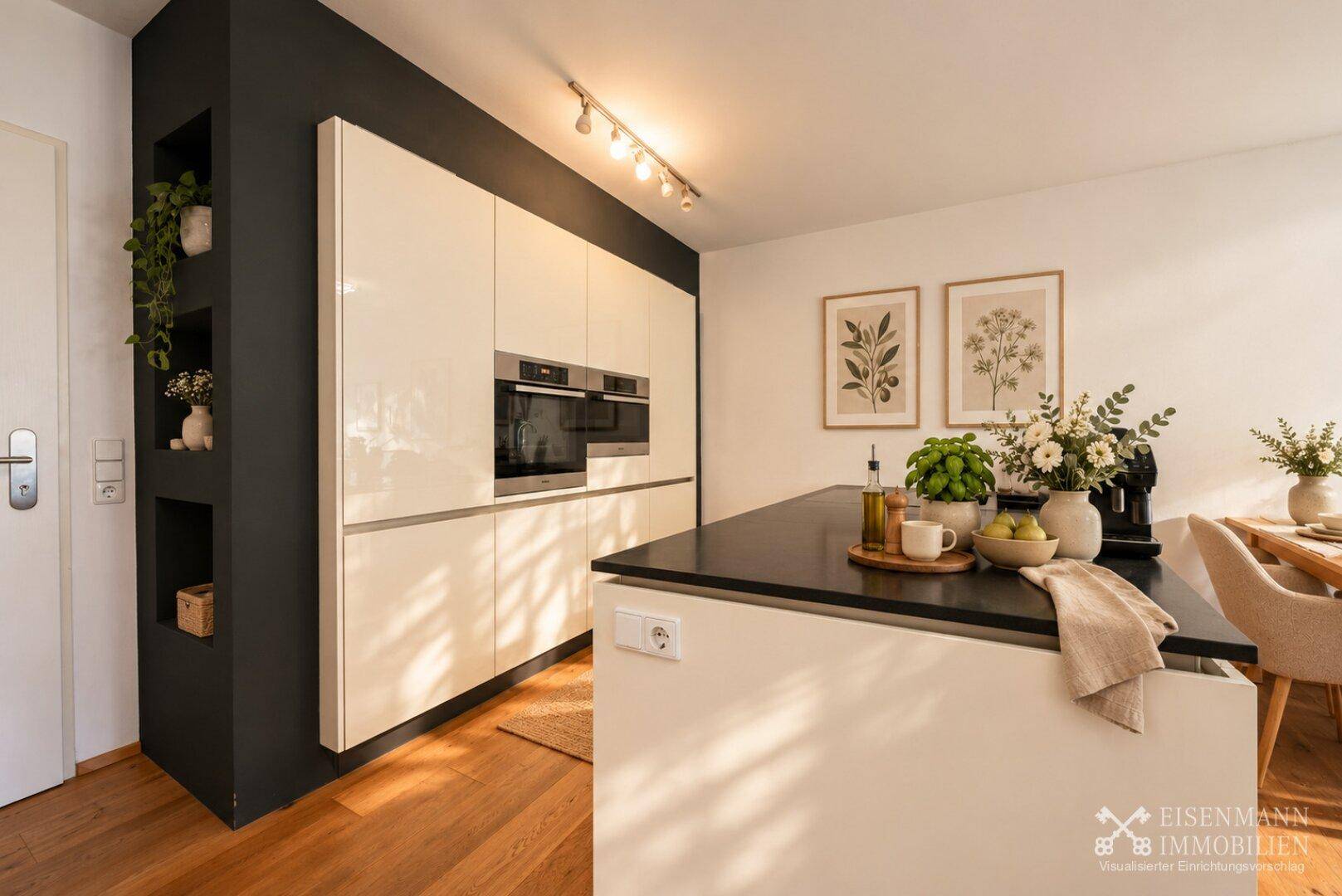 Stilvolle Küche mit cremefarbenen Hochglanzfronten, dunkler Wand und integrierten Backöfen.