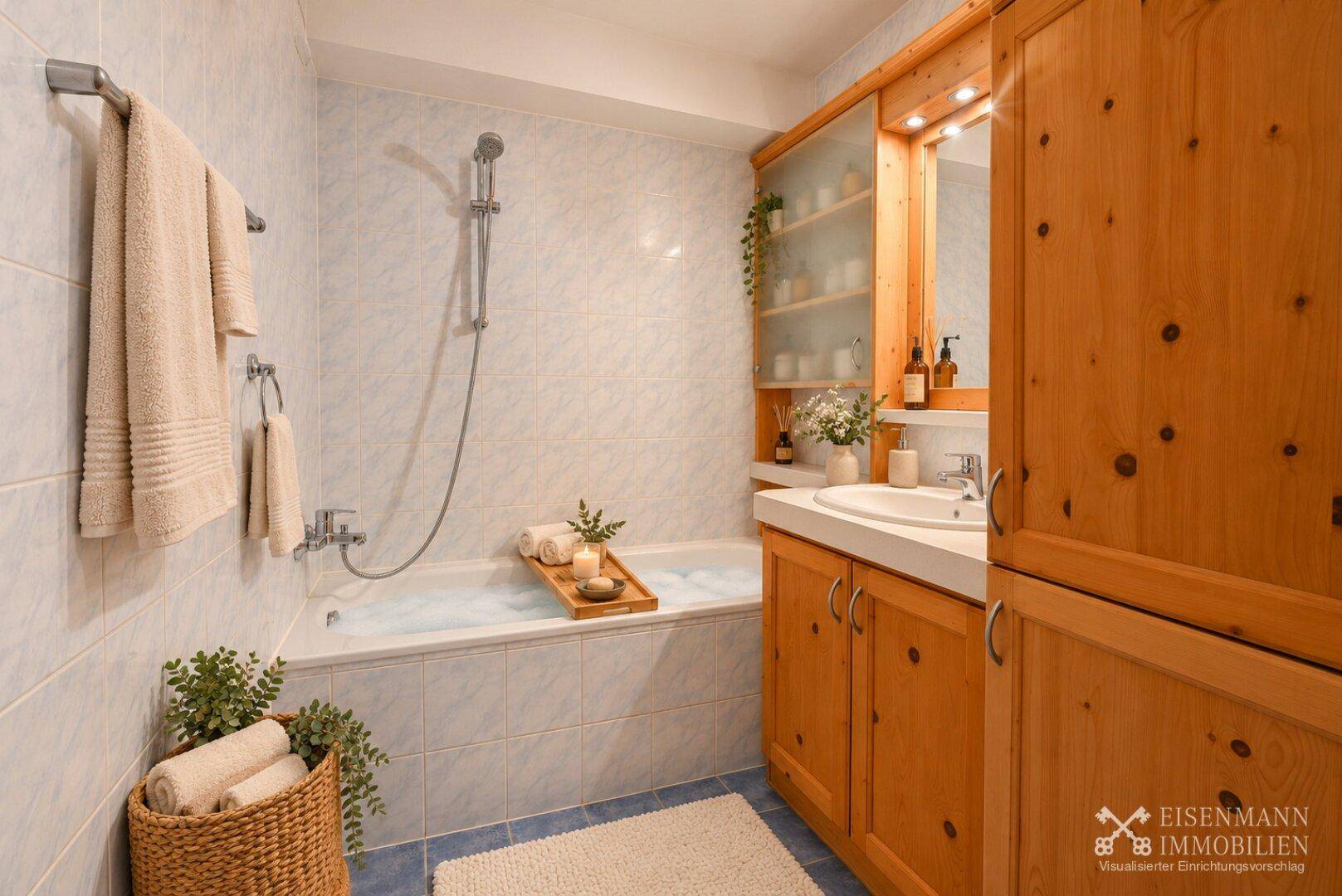 Badezimmer mit Badewanne, hellblauen Fliesen und Holzmöbeln im Landhausstil.