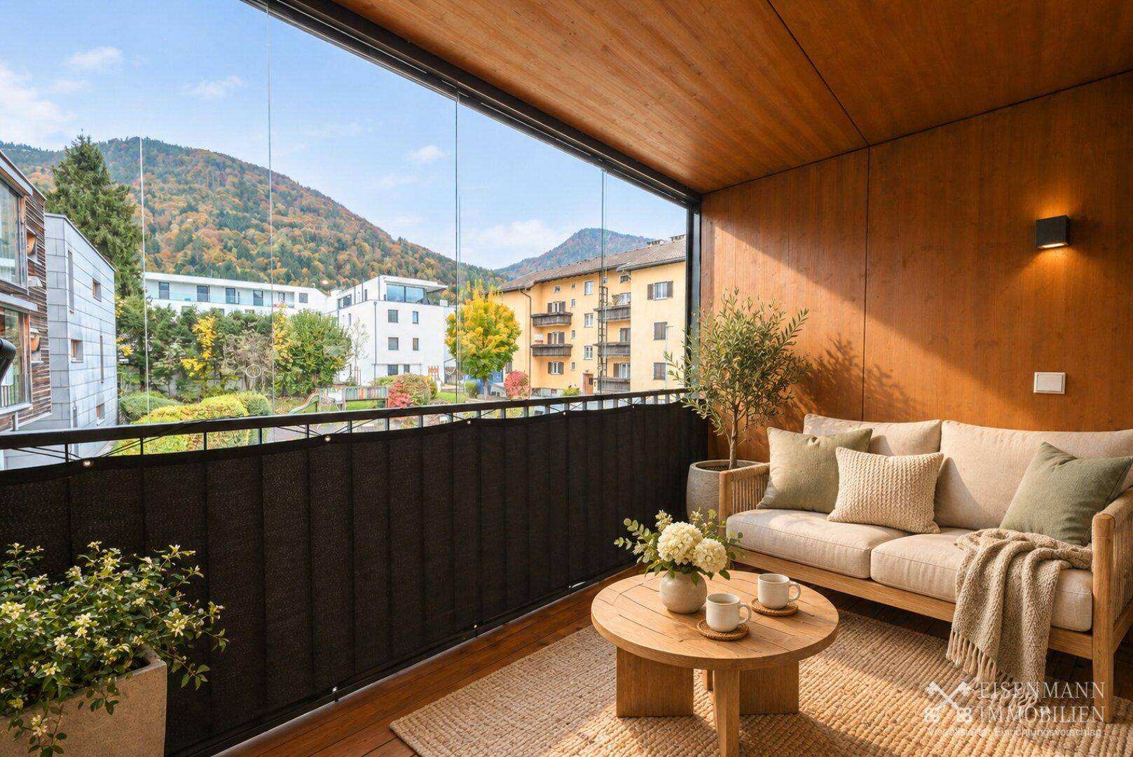 Gemütliche verglaste Loggia mit Sitzgelegenheiten und weitem Blick auf die Berge und Umgebung.