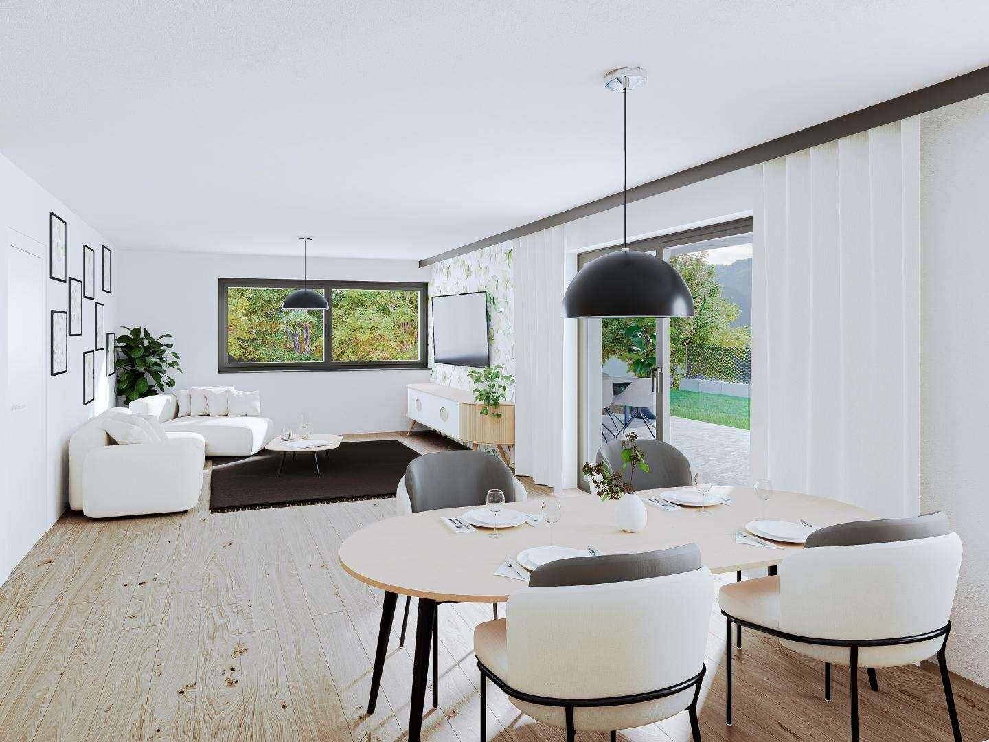 Heller, offener Wohn-Essbereich mit modernem Design, Holzboden und Zugang zur Terrasse mit Grünblick.