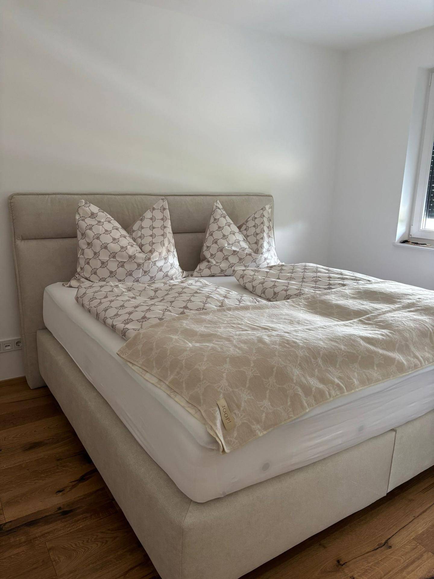 Helles Schlafzimmer mit bequemem Doppelbett und warmem Holzboden.