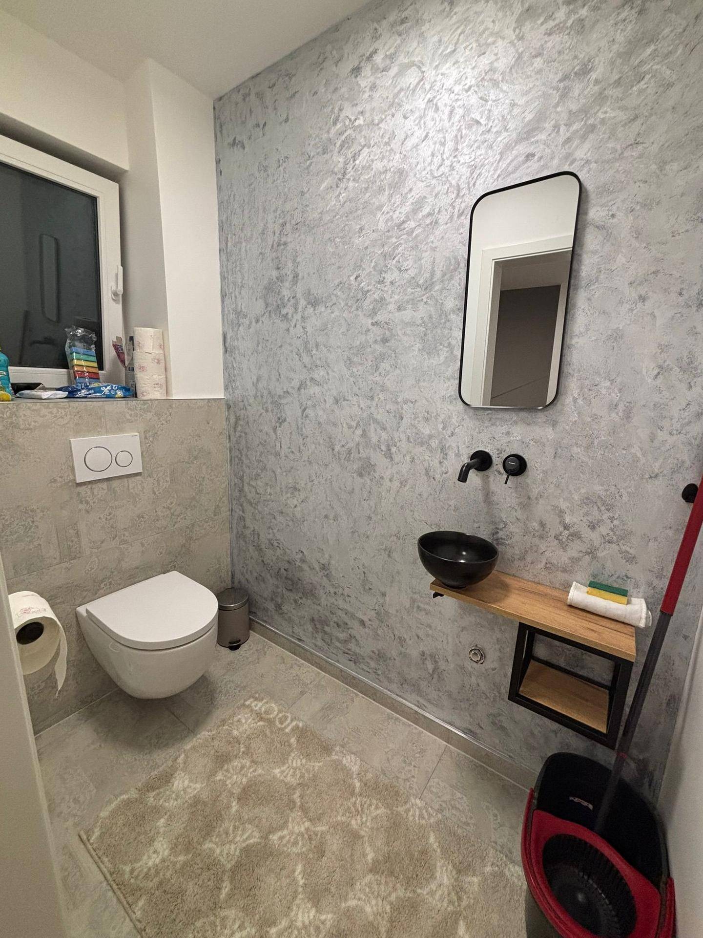 Modernes Gäste-WC mit Wand-WC, stilvollem Waschbecken und Fenster.