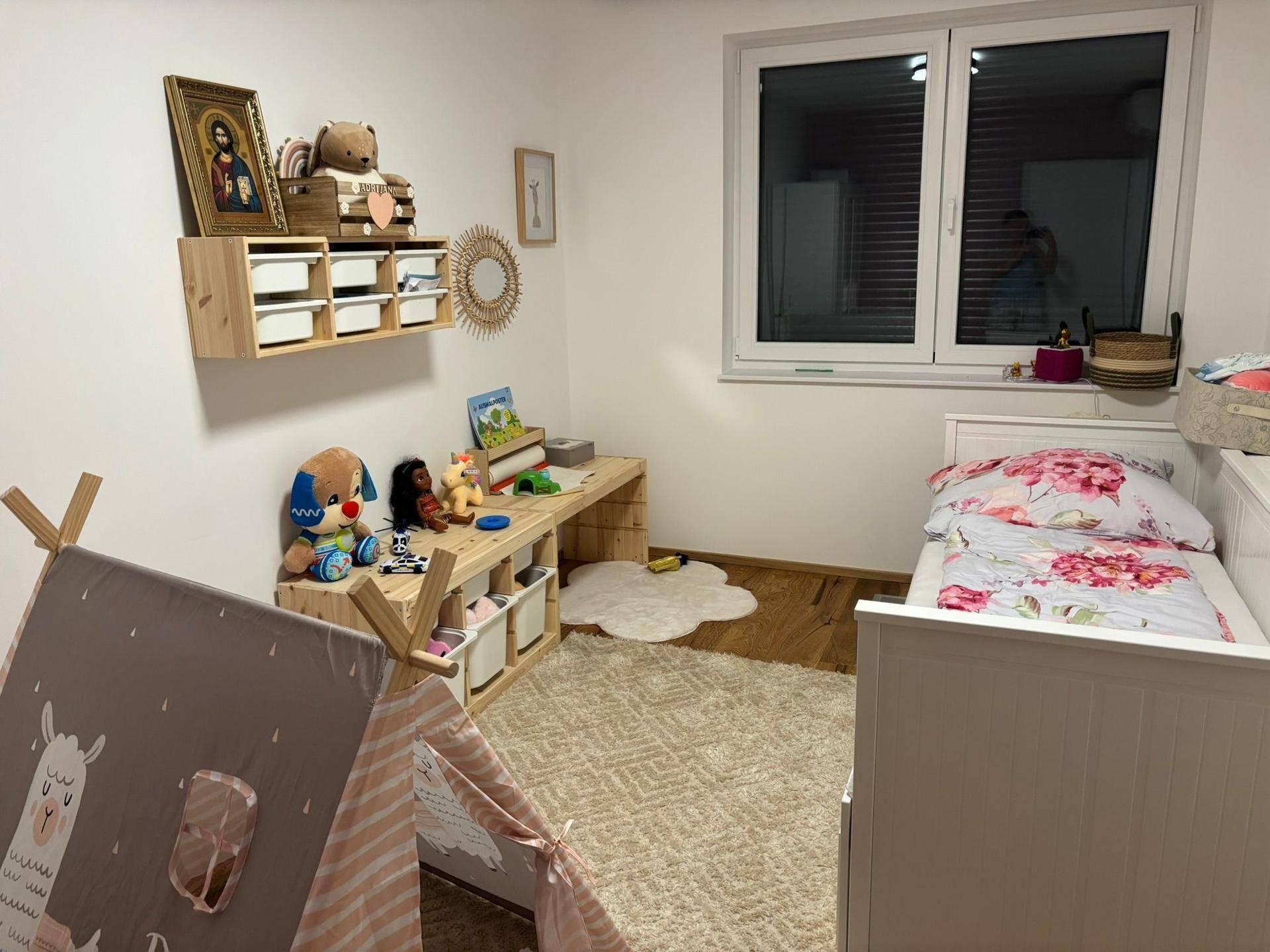Helles Kinderzimmer mit Spielbereich, Einzelbett und Holzboden.