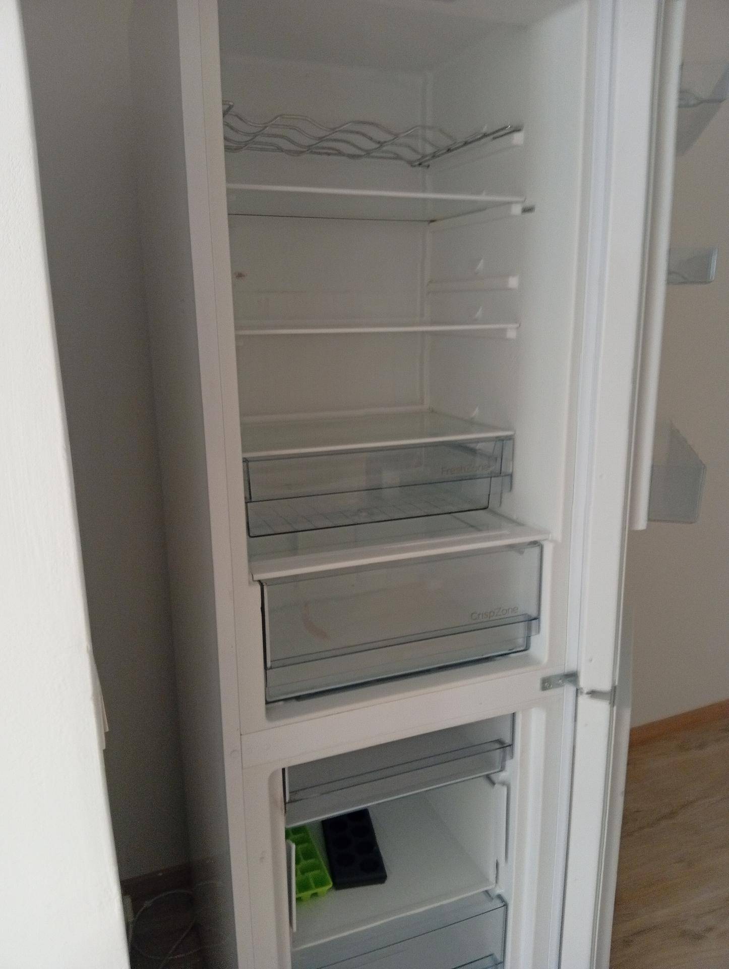 Offener Kühlschrank mit Gefrierfach und mehreren Ablagefächern in einer modernen Küche.