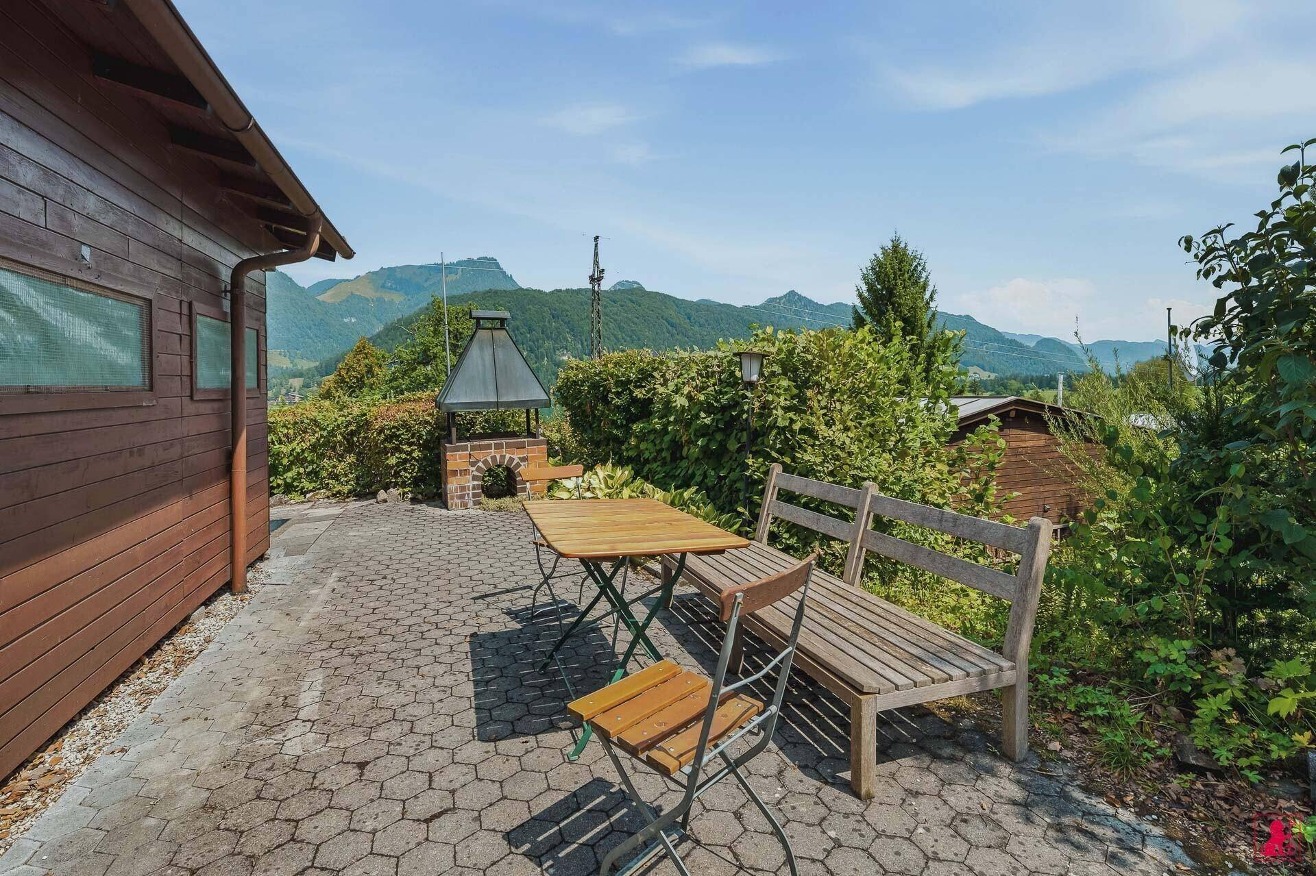 Gemütliche Terrasse mit Holzsitzgelegenheiten und weitem Bergblick.