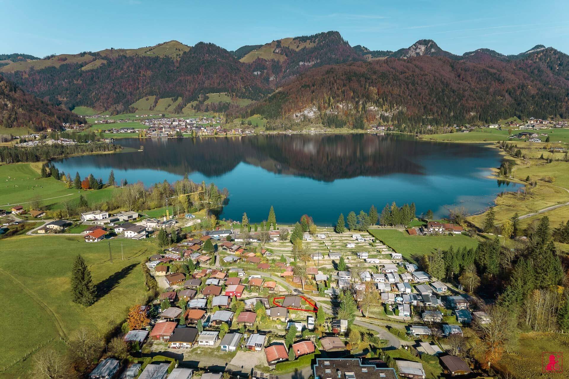 Luftaufnahme des Sees und der umliegenden Landschaft mit vielen kleinen Häusern.